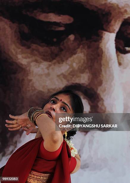 Indian dancers perform at a function organised to celebrate the 150th birth anniversary of poet Rabindranath Tagore, pictured in the background, in...