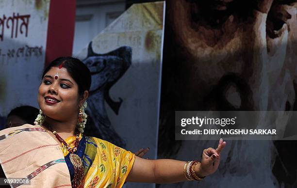 Indian dancers perform at a function organised to celebrate the 150th birth anniversary of poet Rabindranath Tagore, pictured in the background, in...