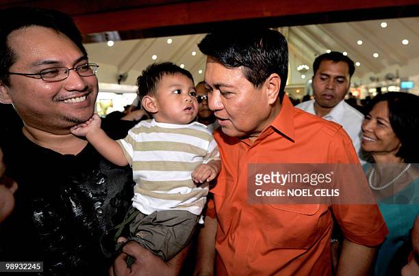 Presidential candidate and senator Manuel Villar greets a boy after attending a mass at a church in Las Pinas, south of Manila on May 9, 2010. More...