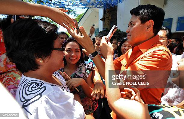 Presidential candidate and senator Manuel Villar greets his supporters after attending a mass at a church in Las Pinas, south of Manila on May 9,...