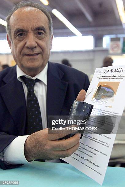 Raoul Parienti, poses with his invention the "Top-braille", a pocket scanner enable the instant transcription of printed words into Braille or voice...
