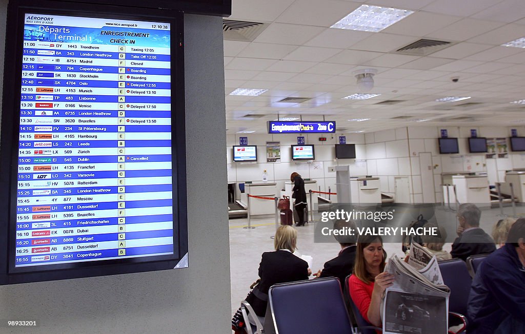 Passengers wait as a board informs about