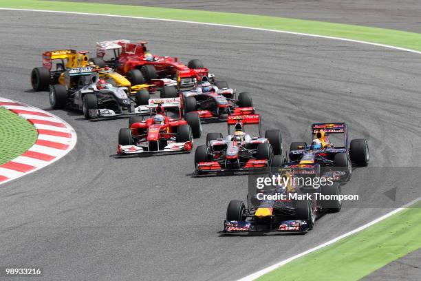 Mark Webber of Australia and Red Bull Racing leads from team mate Sebastian Vettel of Germany and Red Bull Racing and the rest of the field at the...