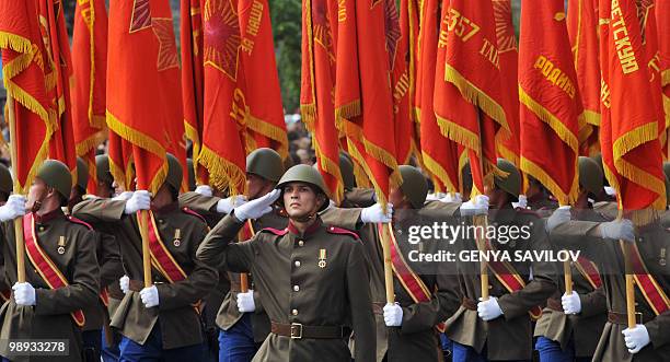 Ukrainian soldiers, wearing Soviet Army uniforms and holding flags of a Soviet World War II unit, march in Kiev on May 9, 2010 during a Victory Day...