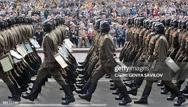 Ukrainian veterans look at Ukrainian soldiers, wearing WWII Soviet army uniforms, marching during the Victory Day military parade, marking the 65th...