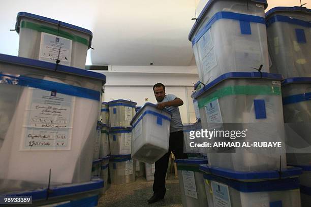 An Iraqi electoral staff member carries a ballot box after votes were recounted in Baghdad on May 9, 2010. The electoral commission has sent results...