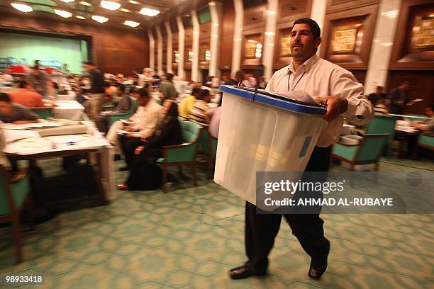 An Iraqi electoral staff member carries a ballot box after votes were recounted in Baghdad on May 9, 2010. The electoral commission has sent results...