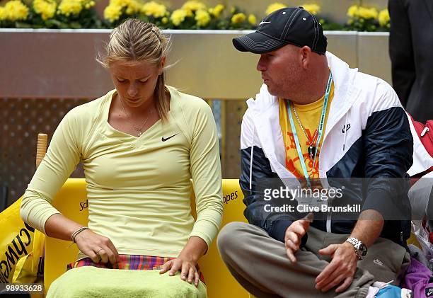 Maria Sharapova of Russia listens to her coach during her straight sets defeat by Lucie Safarova of Czech Republic in their first round match during...