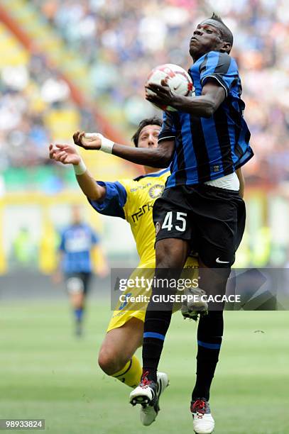 Inter Milan's forward Mario Balotelli challenges for the ball with Chievo defender Francesco Scardina during their Serie A football match Inter Milan...