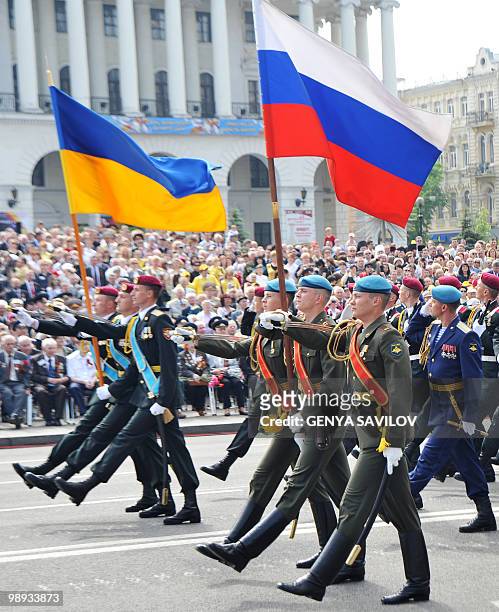 Ukrainian and Russian soldiers carry a national flags during a Victory Day parade in Kiev on May 9, 2010 to mark the 65th anniversary of the end of...