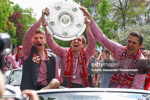 Goalkeeper Hans-Joerg Butt as well as his team mates Philipp Lahm and Thomas Muller celebrate the German championship with the trophy on the way to...