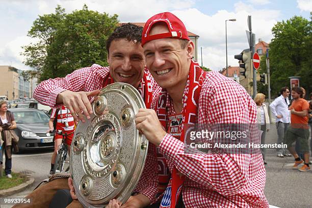 Arjen Robben and his team mate Mark van Bommel celebrate the German championship with the trophy on the way to the champions party at the Marienplatz...