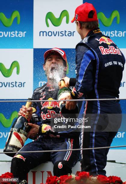 Mark Webber of Australia and Red Bull Racing celebrates on the podium with third placed team mate Sebastian Vettel of Germany and Red Bull Racing...