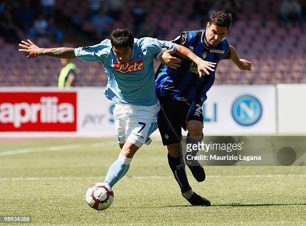 Ezequiel Lavezzi of SSC Napoli battles for the ball with Simone Padoin of Atalanta BC during the Serie A match between SSC Napoli and Atalanta BC at...
