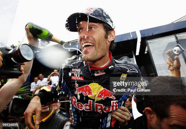 Mark Webber of Australia and Red Bull Racing celebrates with team mates in the paddock after winning the Spanish Formula One Grand Prix at the...