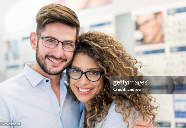 gelukkige paar proberen op glazen op de optische winkel - 2018 glasses stockfoto's en -beelden