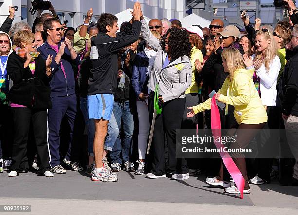 Media personality and physician Dr. Mehmet Oz and media personality Oprah Winfrey trade "high-fives" after cutting the ribbon to signal the start of...