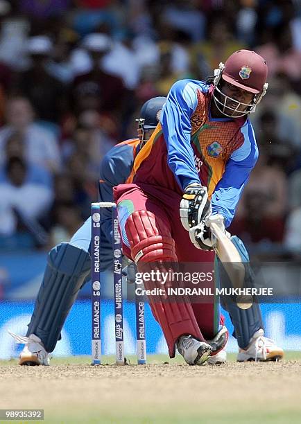 Indian cricketer Mahendra Singh Dhoni looks on as West Indian cricketer Chris Gayle plays a shot during the ICC World Twenty20 Super 8 match between...