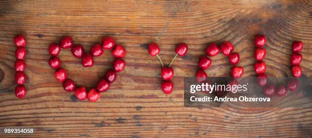 ripe organic homegrown cherries on wooden background, i love you text - cranberry heart stock pictures, royalty-free photos & images