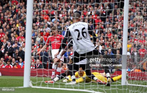 Andre Arshavin of Arsenal threads the ball past Mark Schwarzer of Fulham and Chris Smalling of Fulham to score Arsenal's first goal during the...