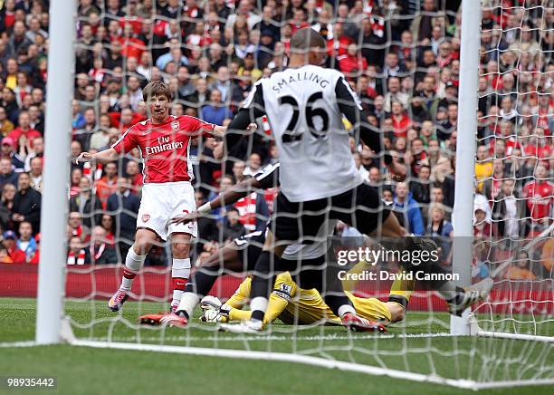 Andre Arshavin of Arsenal threads the ball past Mark Schwarzer of Fulham and Chris Smalling of Fulham to score Arsenal's first goal during the...