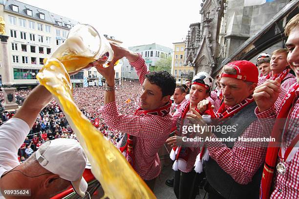 Mark van Bommel of Bayern Muenchen pours beer over entertainer Stefan Lehmann during the German championship title celebration on the balcony of the...