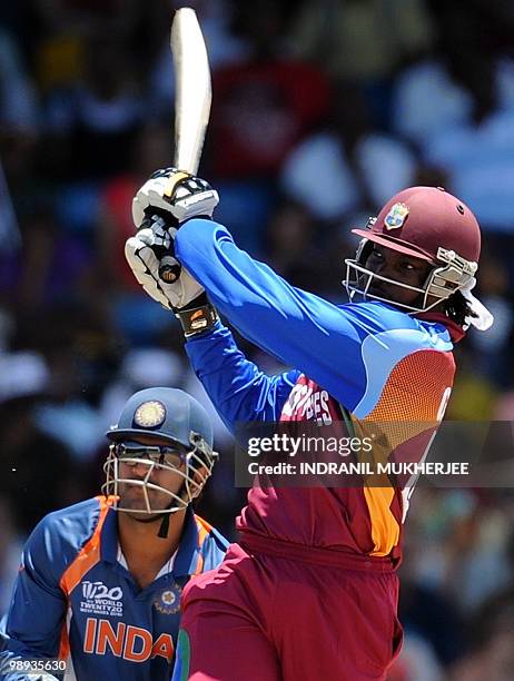 Indian cricketer Mahendra Singh Dhoni reacts as West Indian cricketer Chris Gayle plays a shot during the ICC World Twenty20 Super 8 match between...