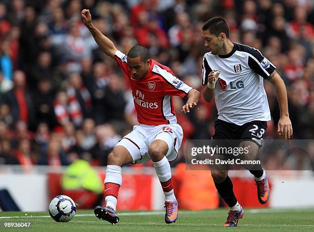 Theo Walcott of Arsenal tussles with Clint Dempsey of Fulham during the Barclays Premier League match between Arsenal and Fulham at The Emirates...