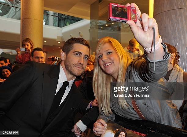 Actor Jake Gyllenhaal poses with a fan as he attends the 'Prince Of Persia: The Sands Of Time' world premiere at the Vue Westfield on May 9, 2010 in...