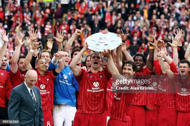 Team captain Martin Amedick of Kaiserslautern holds up the championship trophy with team mates after the Second Bundesliga match between 1. FC...