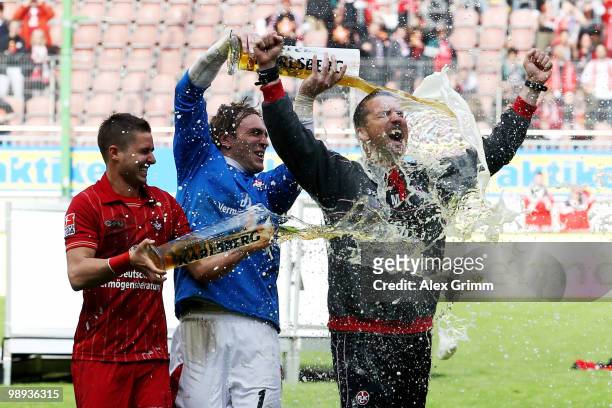 Head coach Marco Kurz of Kaiserslautern is showered with beer by goalkeeper Tobias Sippel and Markus Steinhoefer after the Second Bundesliga match...