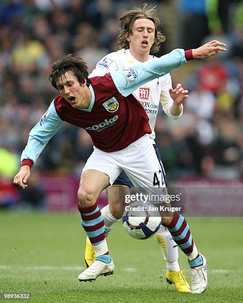 Jack Cork of Burnley goes over under pressure from Luka Modric of Tottenham Hotspur during the Barclays Premier League match between Burnley and...