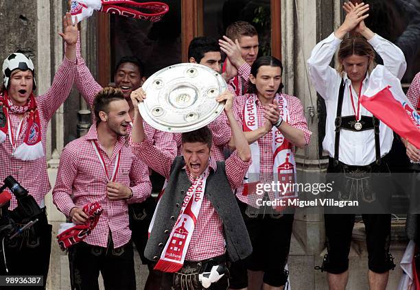 Thomas Mueller presents the German championship trophy on the balcony of the town hall during the champions party on the Marienplatz on May 9, 2010...