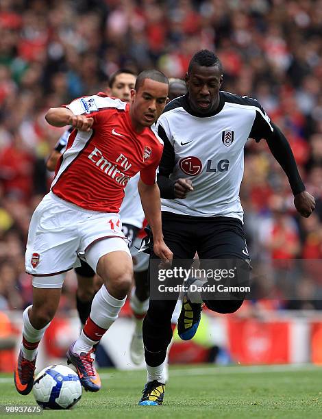 Theo Walcott of Arsenal tussles with Kagisho Dikgacoi of Fulham during the Barclays Premier League match between Arsenal and Fulham at The Emirates...