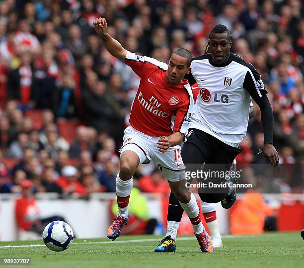 Theo Walcott of Arsenal tussles with Kagisho Dikgacoi of Fulham during the Barclays Premier League match between Arsenal and Fulham at The Emirates...