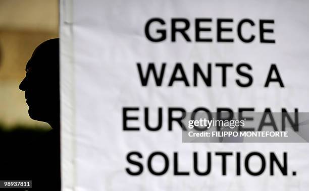 Protestors sits next to a banner, reading: "Greece Wants A European Solution," outside the Greek Parliament in the center of Athens on May 9, 2010....