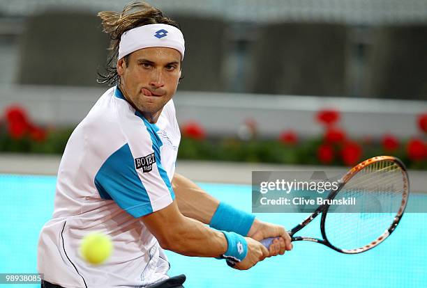 David Ferrer of Spain plays a backhand against Jeremy Chardy of France in their first round match during the Mutua Madrilena Madrid Open tennis...