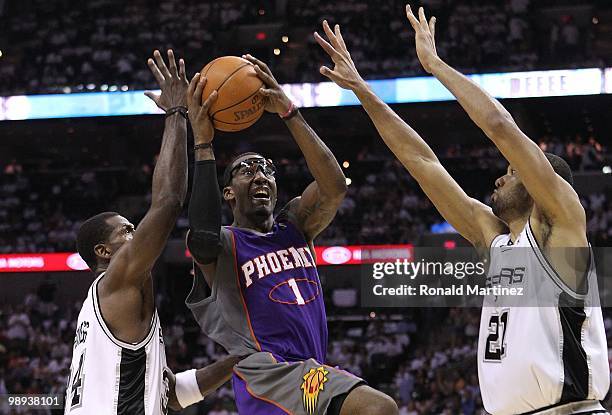 Forward Amar'e Stoudemire of the Phoenix Suns takes a shot against Antonio McDyess and Tim Duncan of the San Antonio Spurs in Game Three of the...