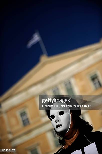Protestor wears a white mask outside the Greek Parliament in the center of Athens on May 9, 2010. Europe vowed to do "whatever is necessary" on May 9...
