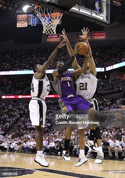 Forward Amar'e Stoudemire of the Phoenix Suns takes a shot against Antonio McDyess and Tim Duncan of the San Antonio Spurs in Game Three of the...