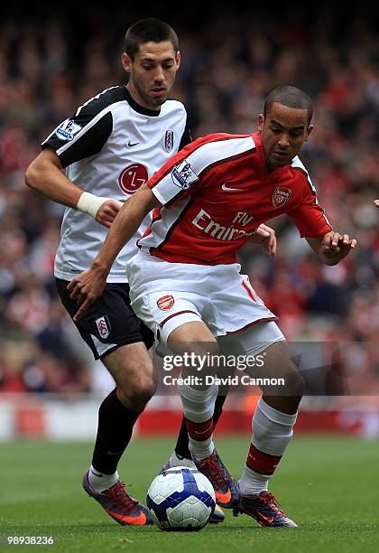 Theo Walcott of Arsenal tussles with Clint Dempsey of Fulham during the Barclays Premier League match between Arsenal and Fulham at The Emirates...