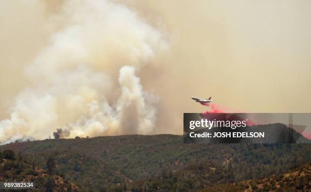 An air tanker drops retardant ahead of a fire line as the County Fire burns near Brooks, California, on July 1, 2018. Californian authorities have...