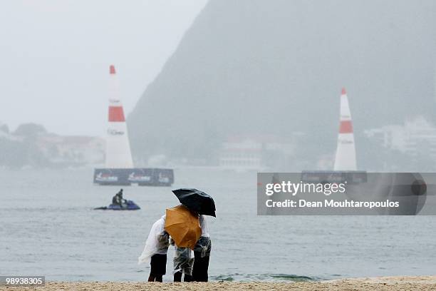 Fans wait on the beach in the rain as Sugar Loaf Mountain during the Red Bull Air Race Day on May 9, 2010 in Rio de Janeiro, Brazil.