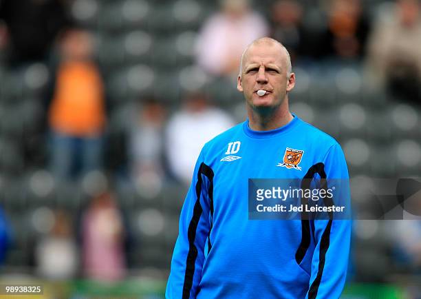 Hull City interim manager Iain Dowie blows bubbles with his bubble gum during the Barclays Premier League match between Hull City and Liverpool at...