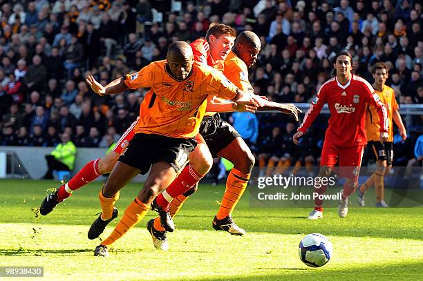 Steven Gerrard of Liverpool competes with Steven Mouyokolo of Hull City during the Barclays Premier League match between Hull City and Liverpool at...