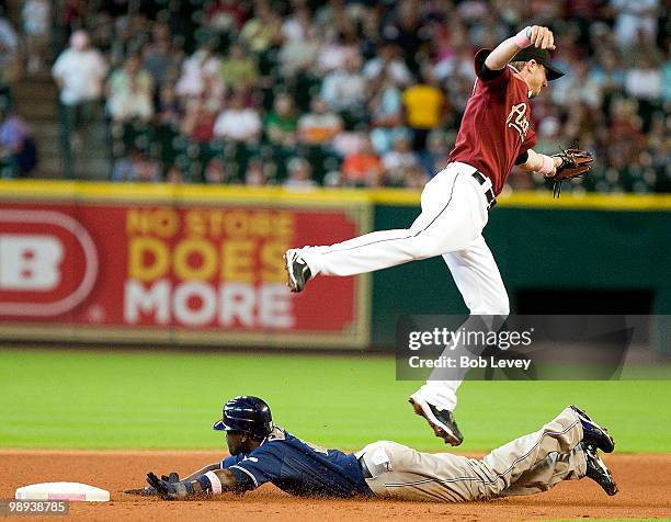 Tony Gwynn of the San Diego Padres slides safely into second base as shortstop Tommy Manzella of the Houston Astros leaps to get the high throw at...