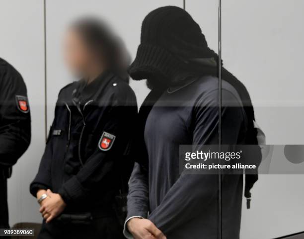 Radical Iraqi preacher and IS main recruiter in Germany, Abu Walaa , covers his face as he arrives for his trial at the Higher Regional Court in...