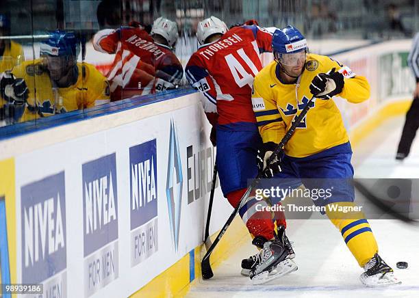 Marcus Nilson of Sweden battles for the puck with Patrick Thoresen of Norway during the IIHF World Championship group C match between Czech Republic...