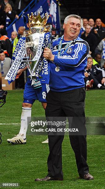 Chelsea's Italian manager Carlo Ancelotti celebrates with the Barclays Premier league trophy after they win the title with a 8-0 victory over Wigan...