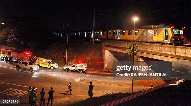 Police, paramedics and ambulance personel look on at the scene where passengers had jumped off of a Metro rail train after part of the train carriage...